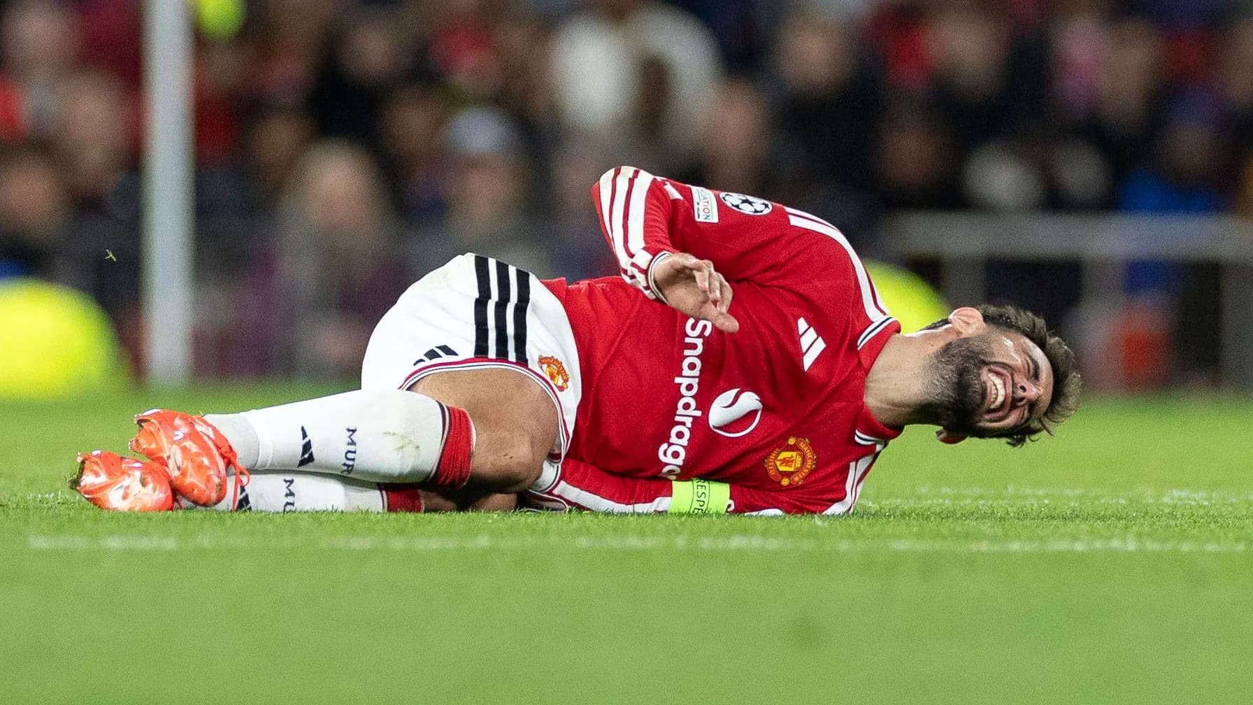 Jugador de Manchester United caído en el campo Jugador de Manchester United caído en el campo