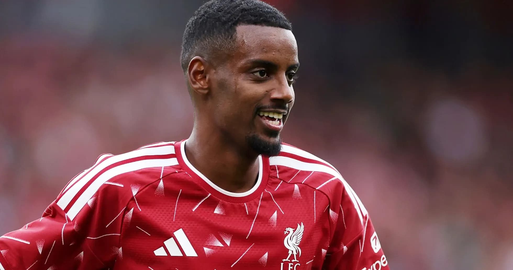 Jugador de Liverpool sonriendo en camiseta roja Jugador de Liverpool sonriendo en camiseta roja