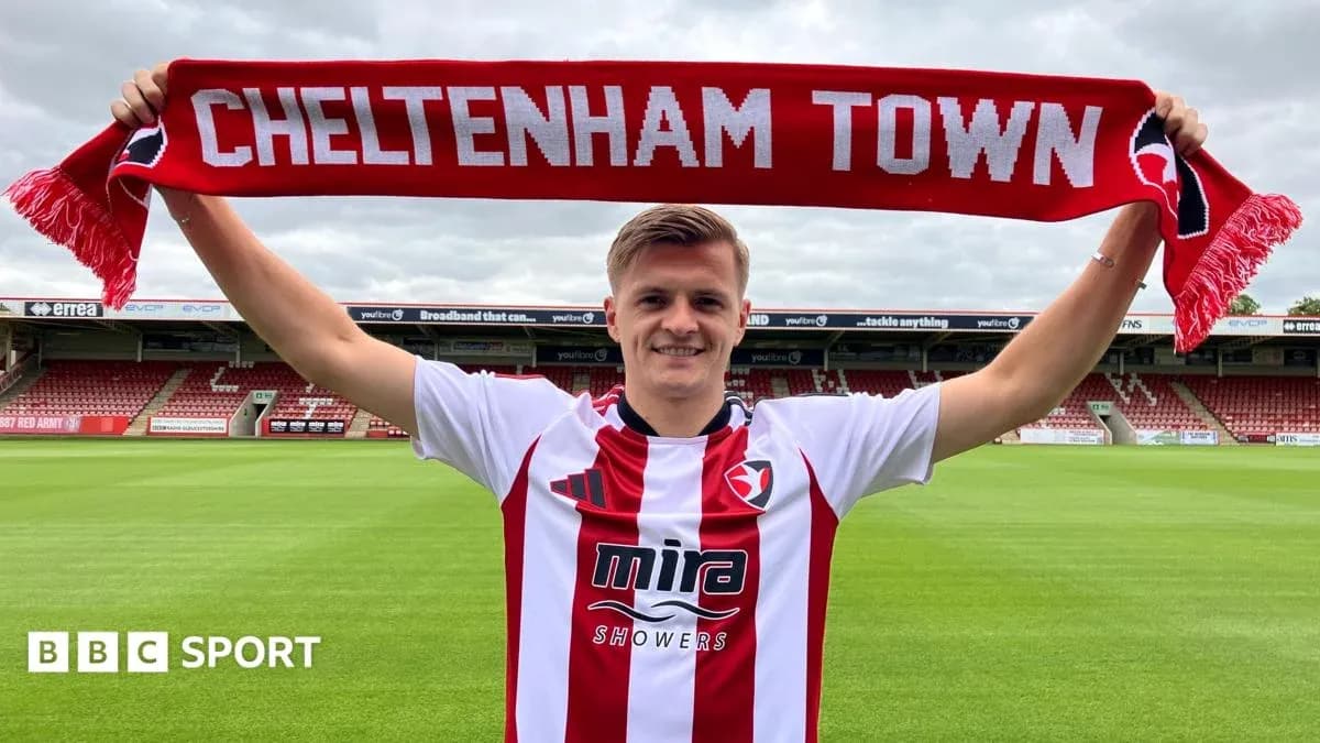 Jugador sostiene una bufanda de Cheltenham Town en el estadio Jugador sostiene una bufanda de Cheltenham Town en el estadio