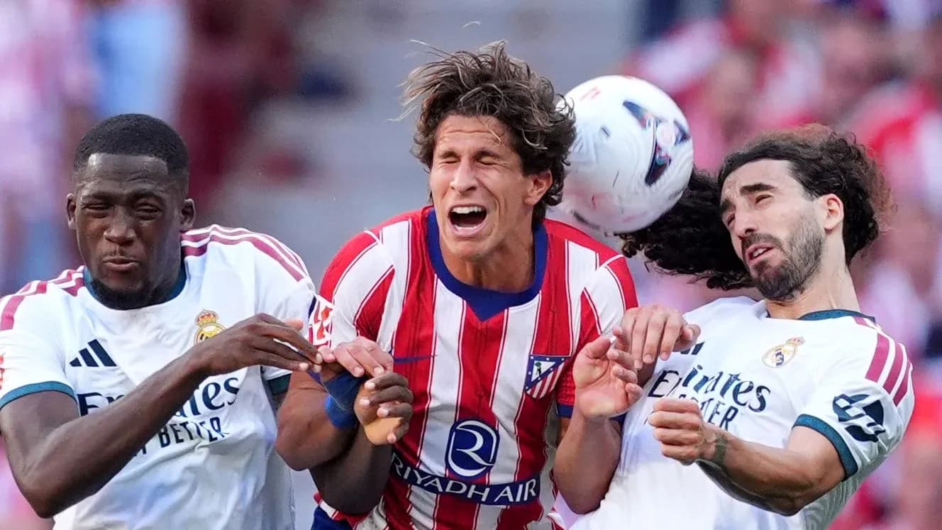 Tres jugadores en disputa por el balón en partido Tres jugadores en disputa por el balón en partido