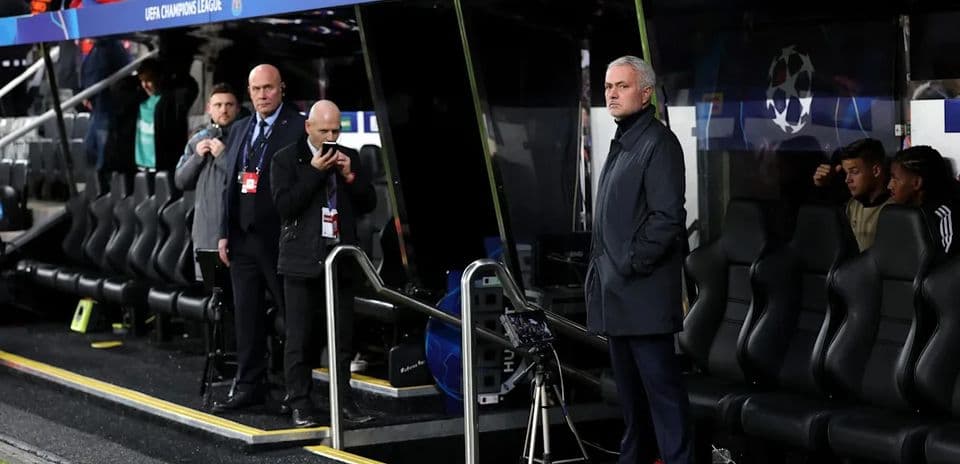 Entrenador observando desde el banquillo en partido Entrenador observando desde el banquillo en partido