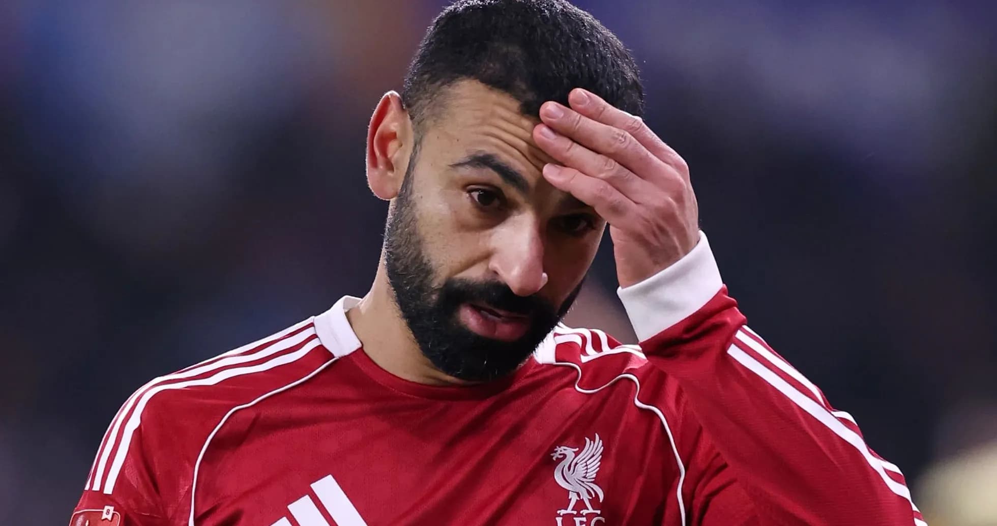 Jugador de Liverpool con camiseta roja, preocupado Jugador de Liverpool con camiseta roja, preocupado
