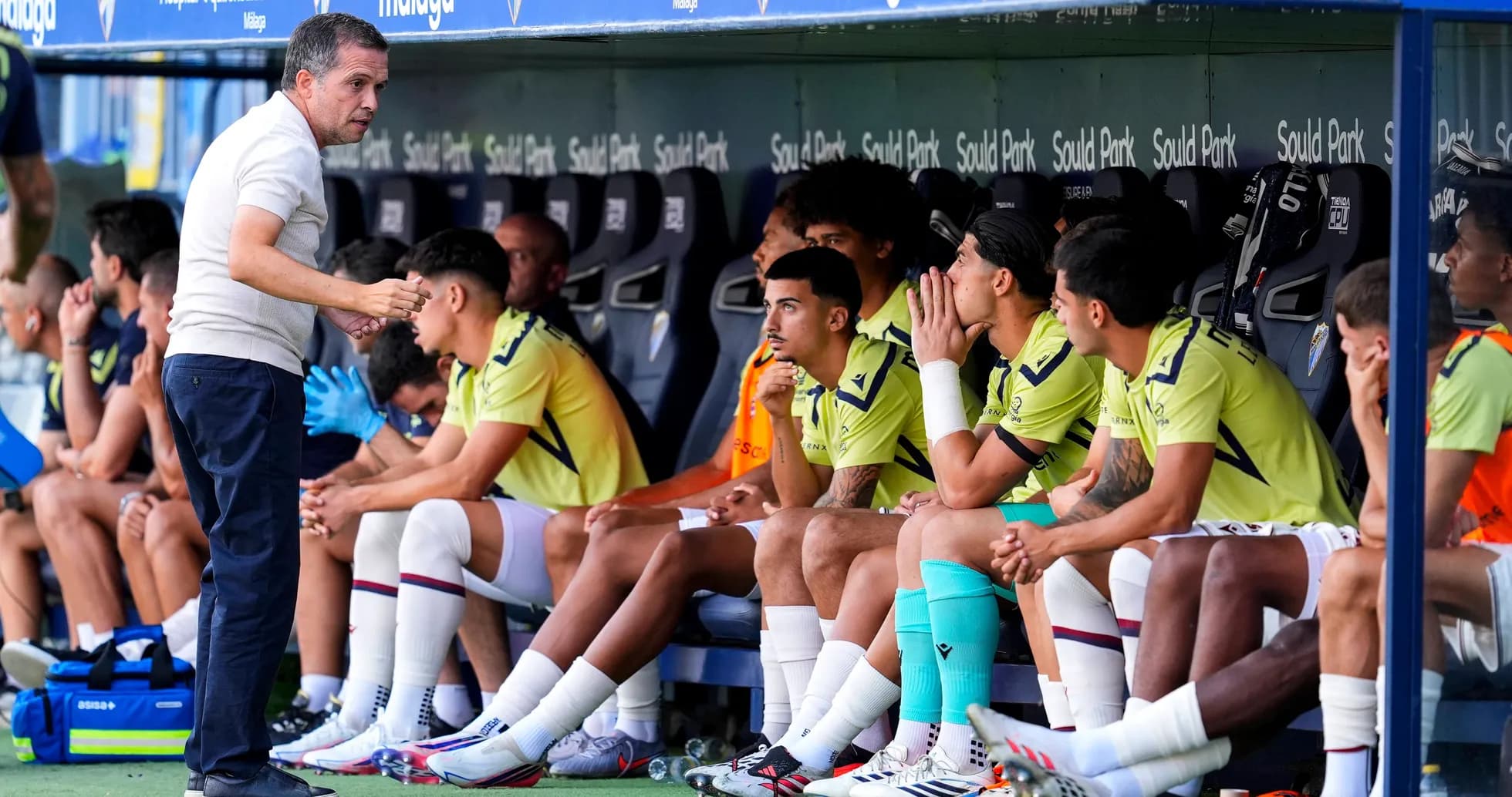 Entrenador hablando con jugadores en el banquillo Entrenador hablando con jugadores en el banquillo