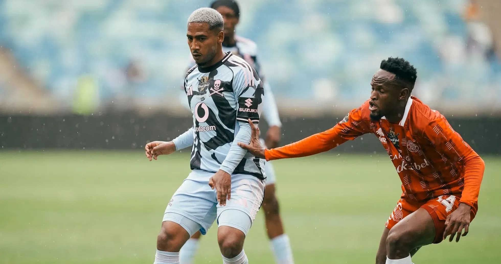 Jugador de fútbol esquivando a oponente en campo lluvioso Jugador de fútbol esquivando a oponente en campo lluvioso