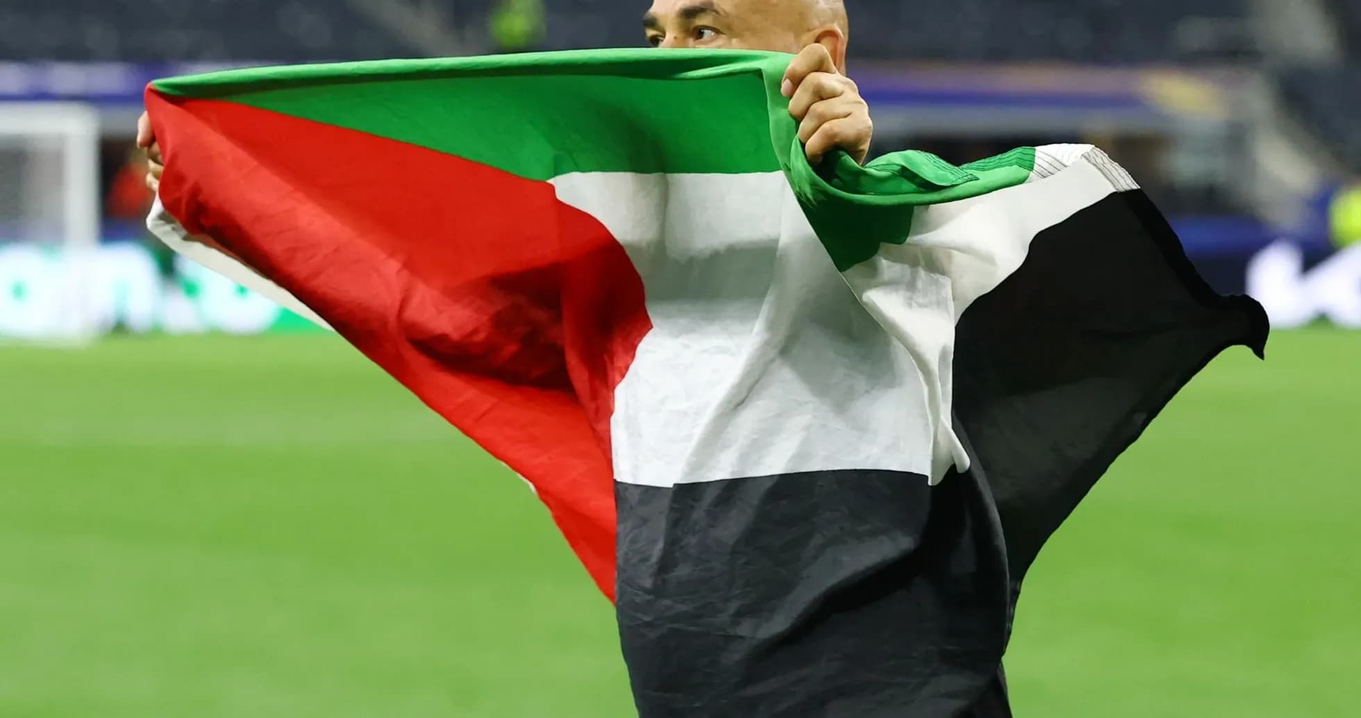 Hombre sosteniendo una bandera en el campo de juego Hombre sosteniendo una bandera en el campo de juego