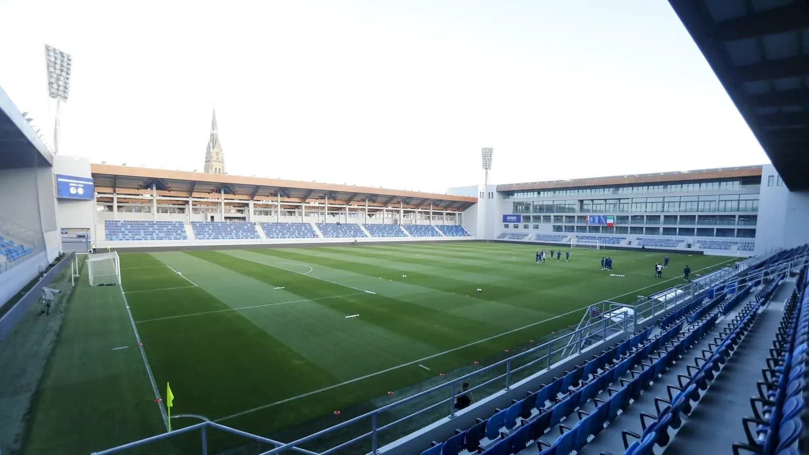 Vista del campo de fútbol con jugadores entrenando Vista del campo de fútbol con jugadores entrenando