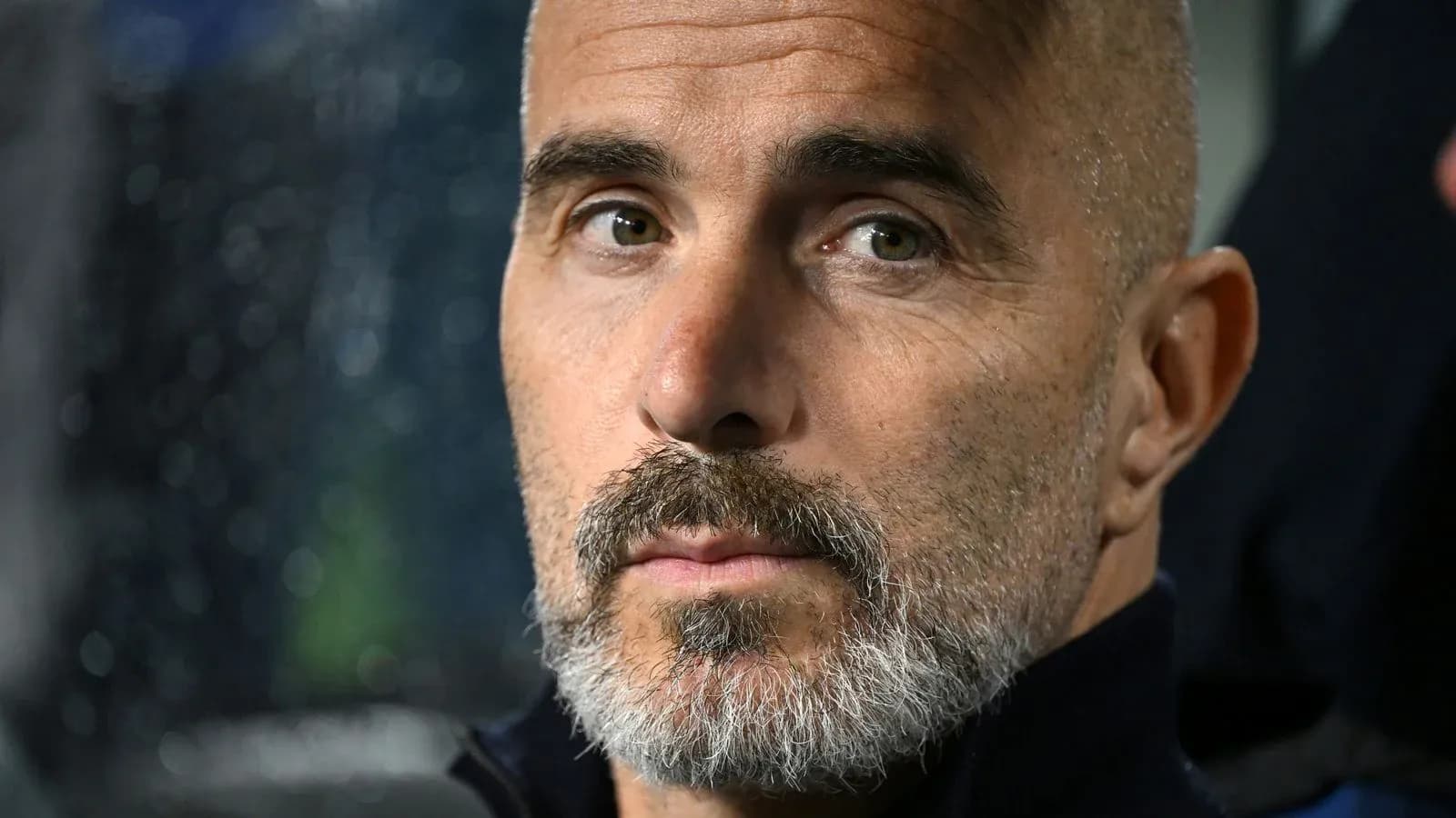 Entrenador observando desde el banquillo durante el partido Entrenador observando desde el banquillo durante el partido