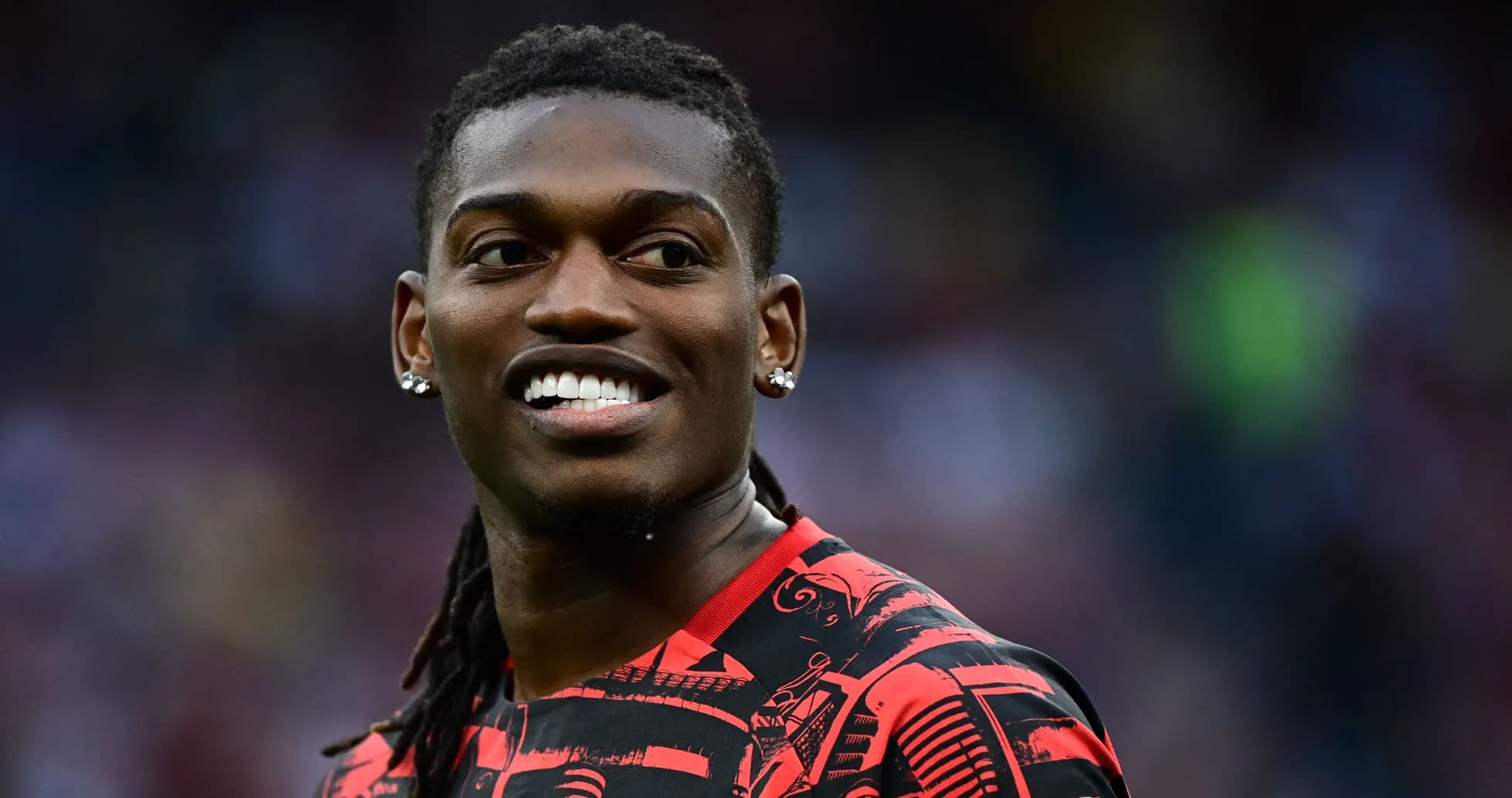 Jugador sonriendo con camiseta roja y negra Jugador sonriendo con camiseta roja y negra