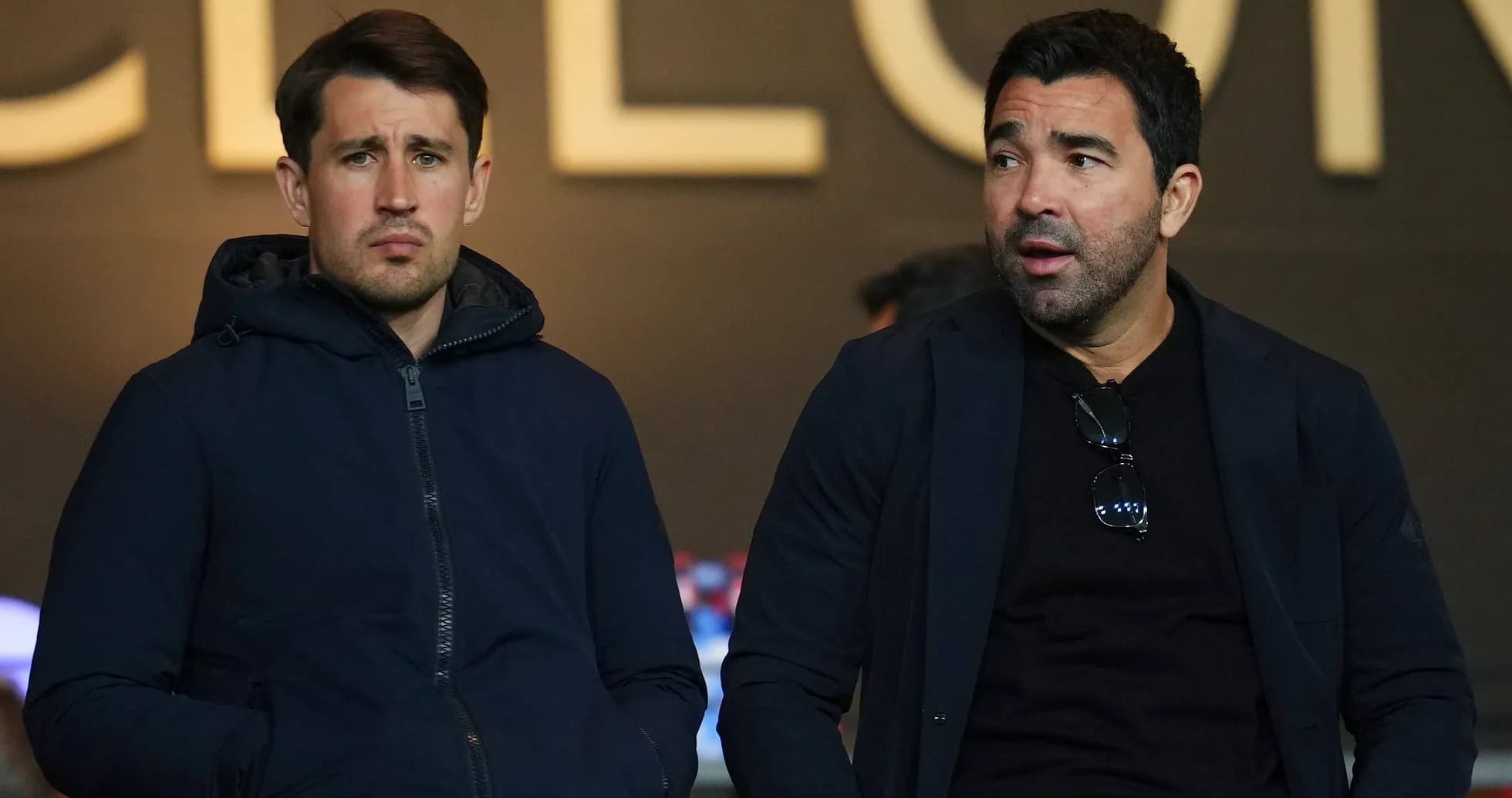 Dos hombres sentados en un evento deportivo Dos hombres sentados en un evento deportivo