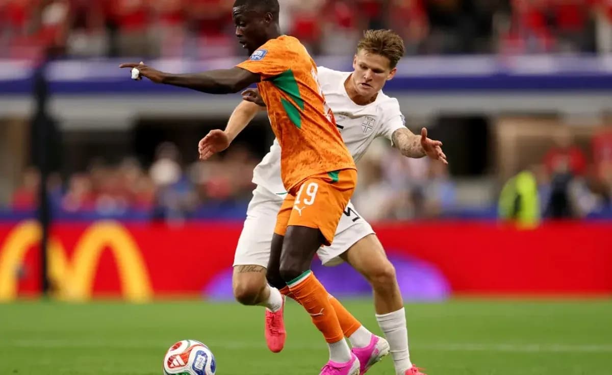 Jugador con camiseta naranja driblando a oponente en blanco Jugador con camiseta naranja driblando a oponente en blanco