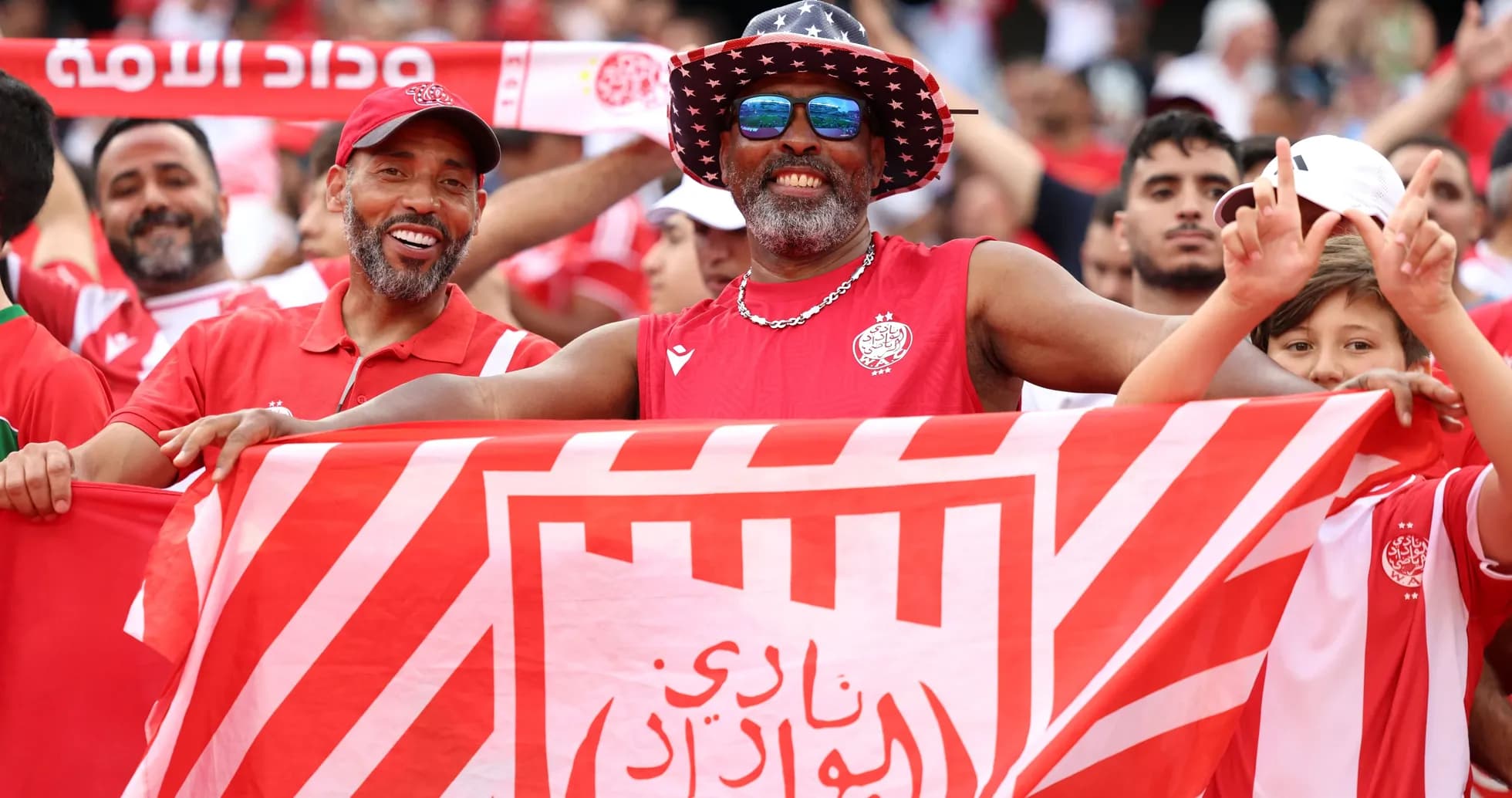 Aficionados sosteniendo una bandera en el estadio Aficionados sosteniendo una bandera en el estadio