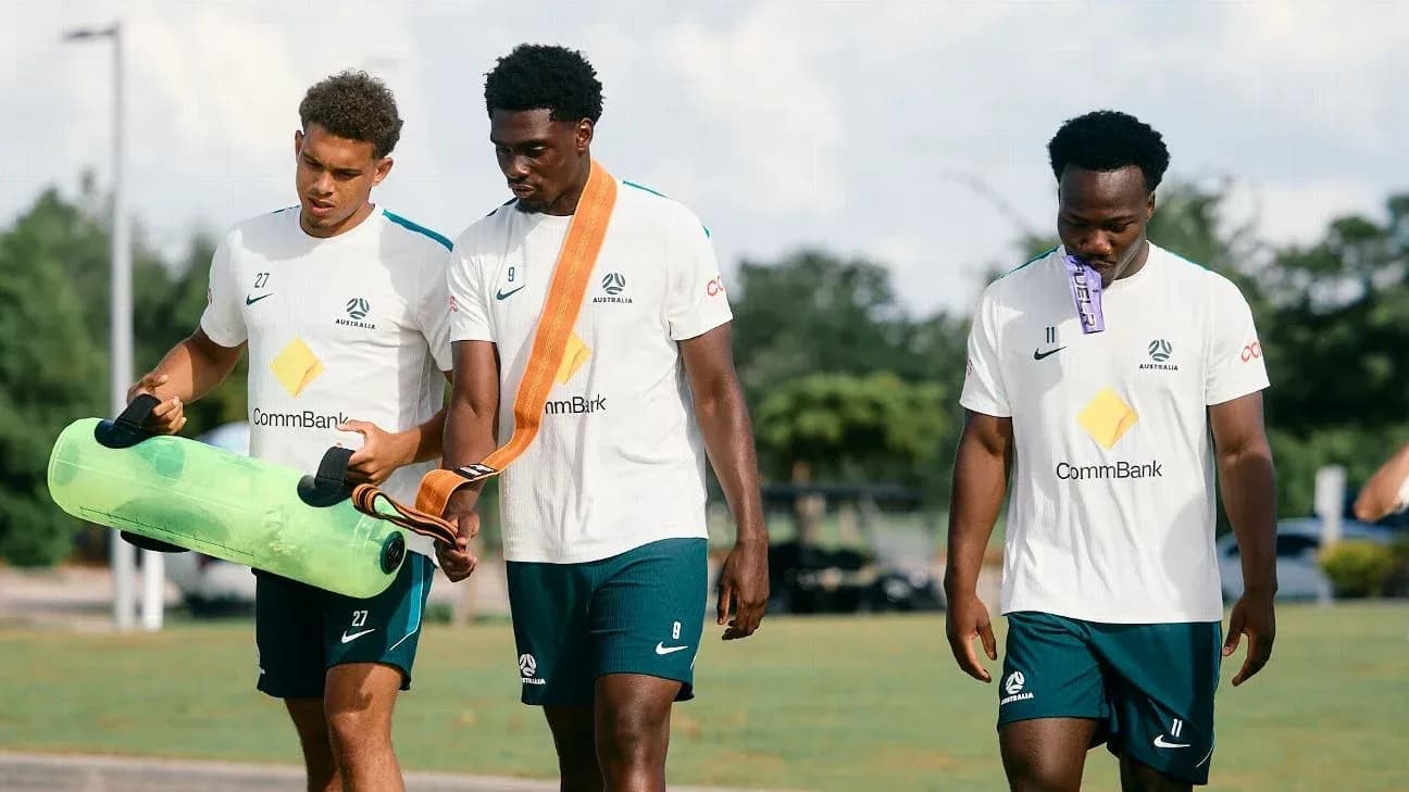 Tres jugadores de fútbol caminando durante entrenamiento Tres jugadores de fútbol caminando durante entrenamiento