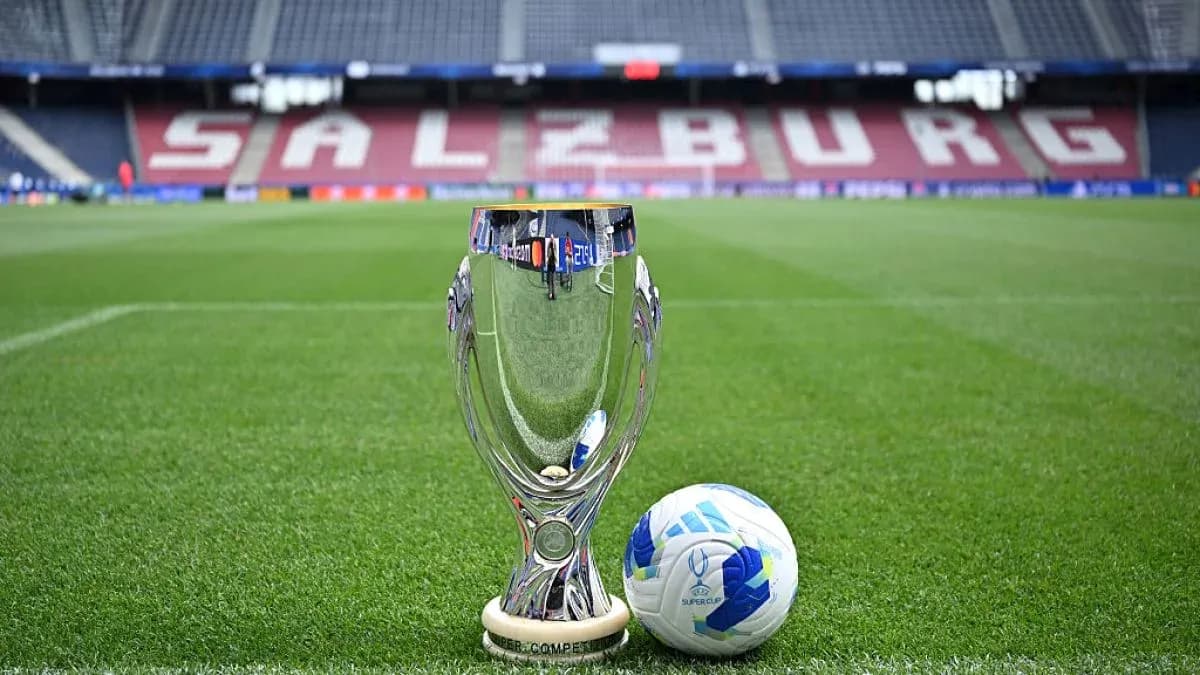 Trofeo y balón de fútbol en campo de juego Trofeo y balón de fútbol en campo de juego