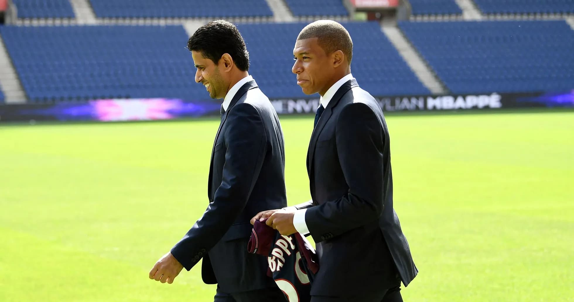 Kylian Mbappé y directivo caminando en el campo Kylian Mbappé y directivo caminando en el campo