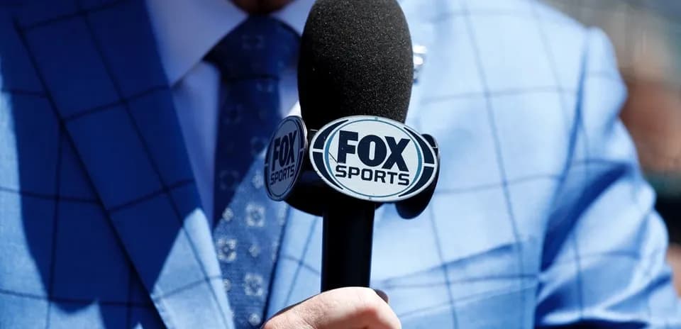 Mic labeled 'FOX Sports' held by a person Mic labeled 'FOX Sports' held by a person