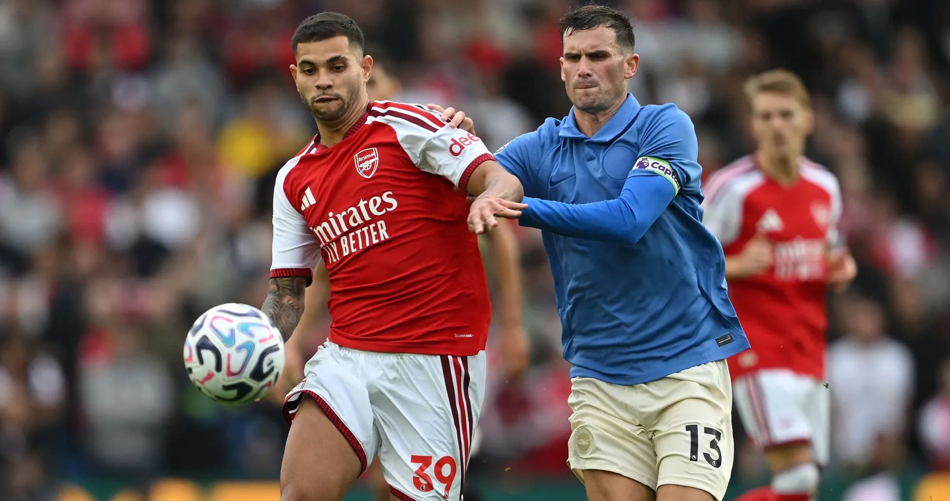 Jugador de Arsenal driblando mientras es marcado Jugador de Arsenal driblando mientras es marcado