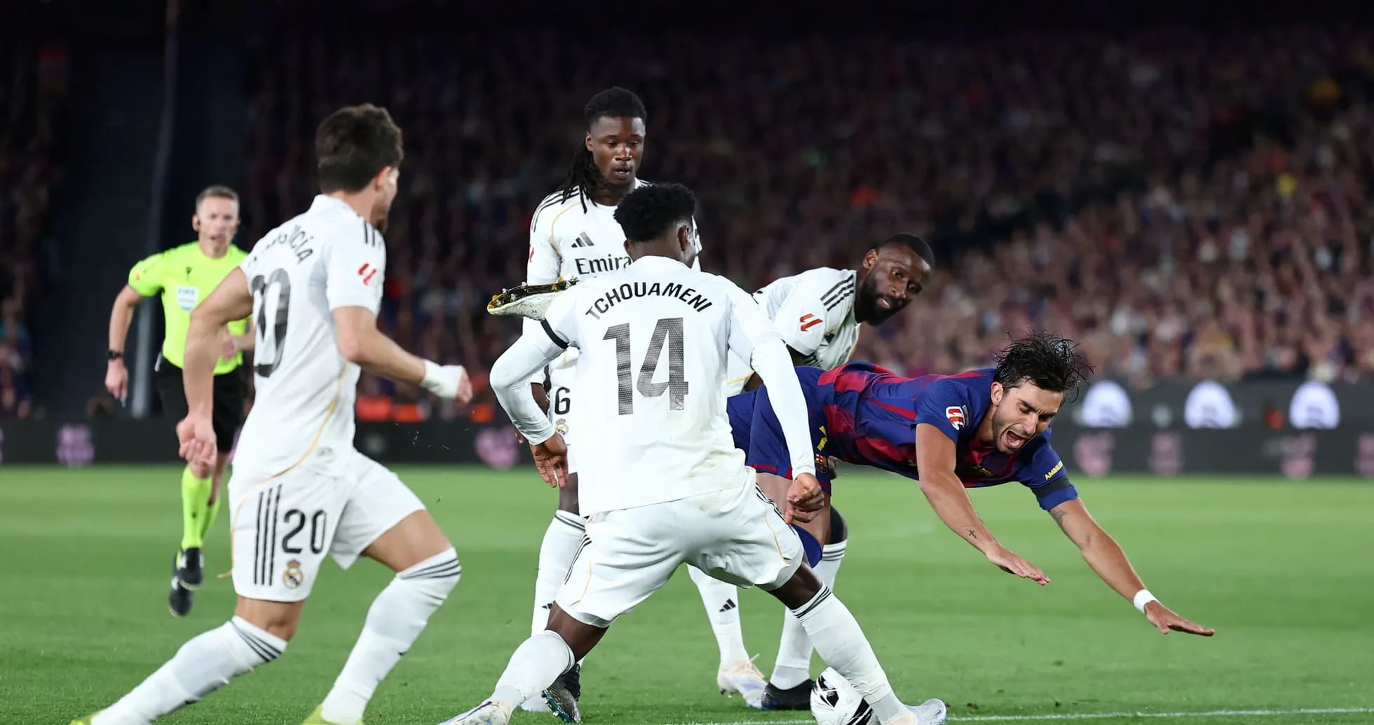 Jugador de Barcelona cayendo entre defensores del Real Madrid Jugador de Barcelona cayendo entre defensores del Real Madrid