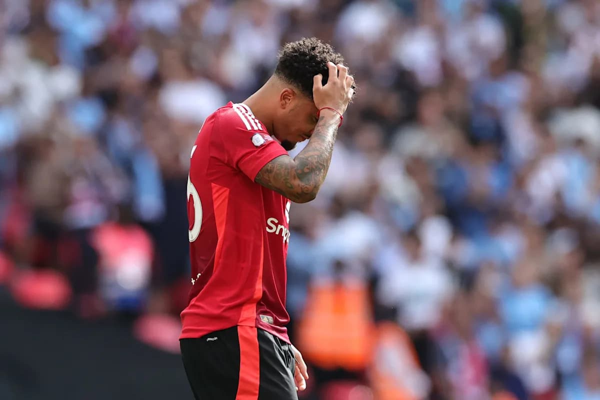 Jugador con camiseta roja sosteniendo su cabeza en el campo Jugador con camiseta roja sosteniendo su cabeza en el campo