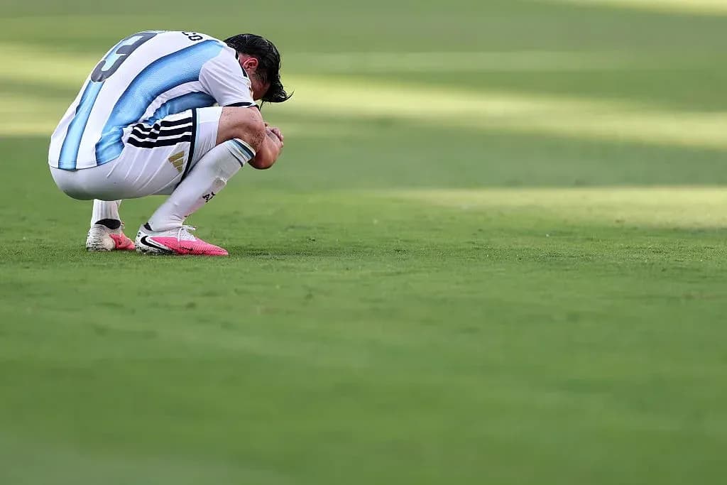 Jugador argentino agachado en el campo de juego Jugador argentino agachado en el campo de juego