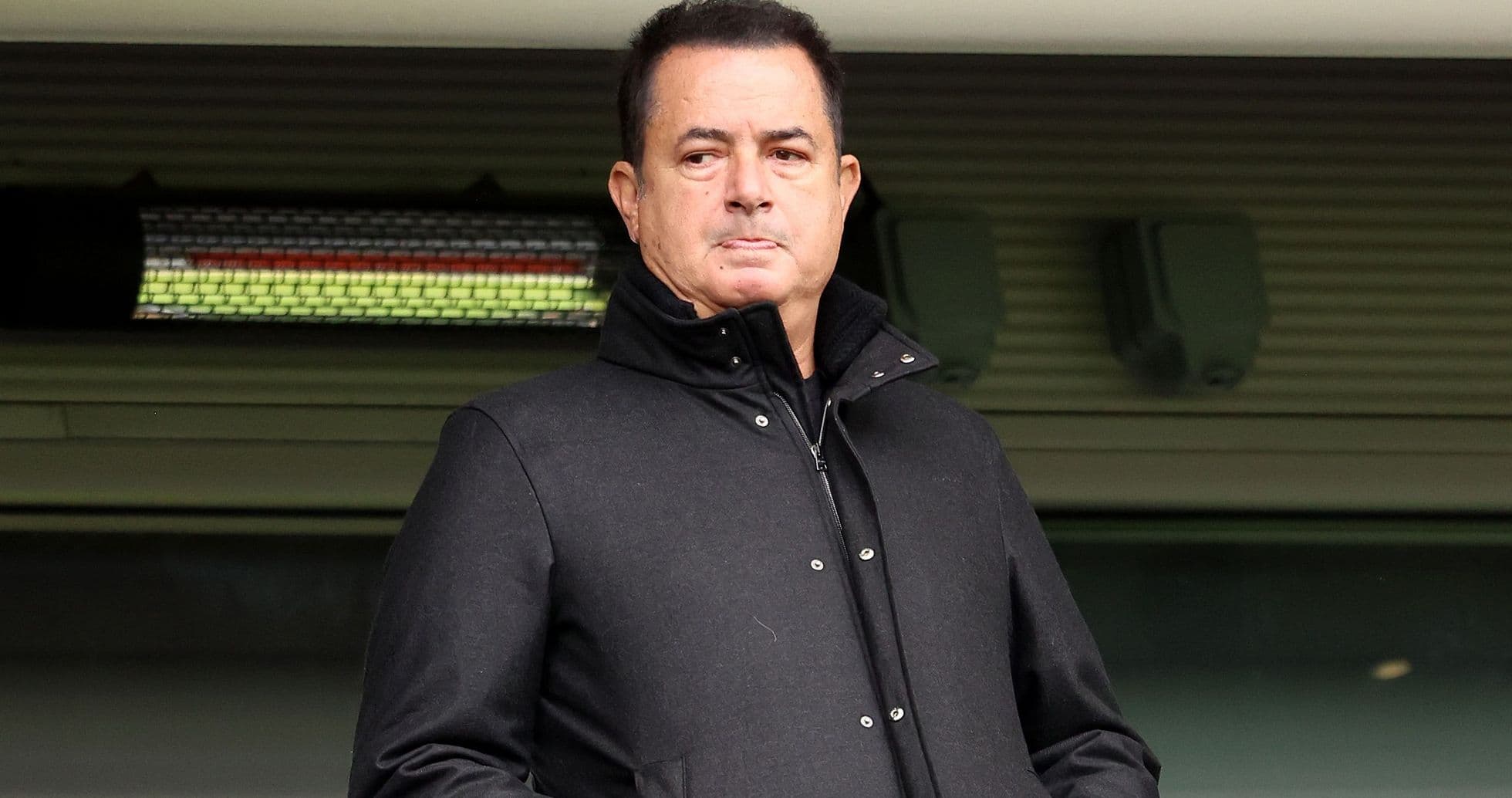 Hombre en abrigo negro observando desde la tribuna Hombre en abrigo negro observando desde la tribuna