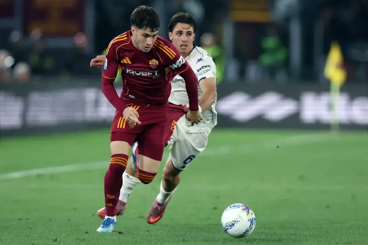Jugador de Roma driblando mientras es seguido por oponente Jugador de Roma driblando mientras es seguido por oponente