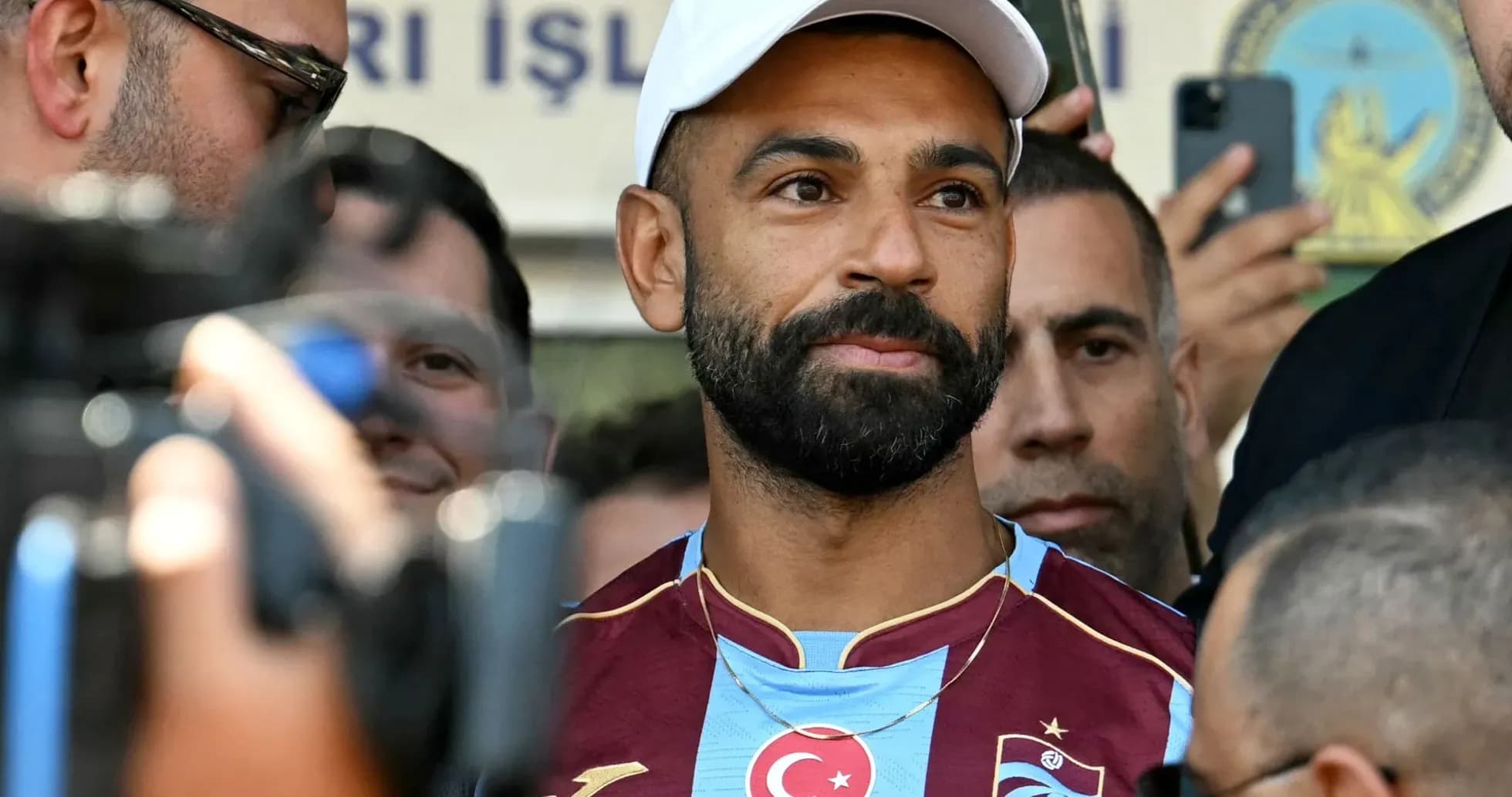 Jugador con camiseta de Trabzonspor rodeado de personas Jugador con camiseta de Trabzonspor rodeado de personas