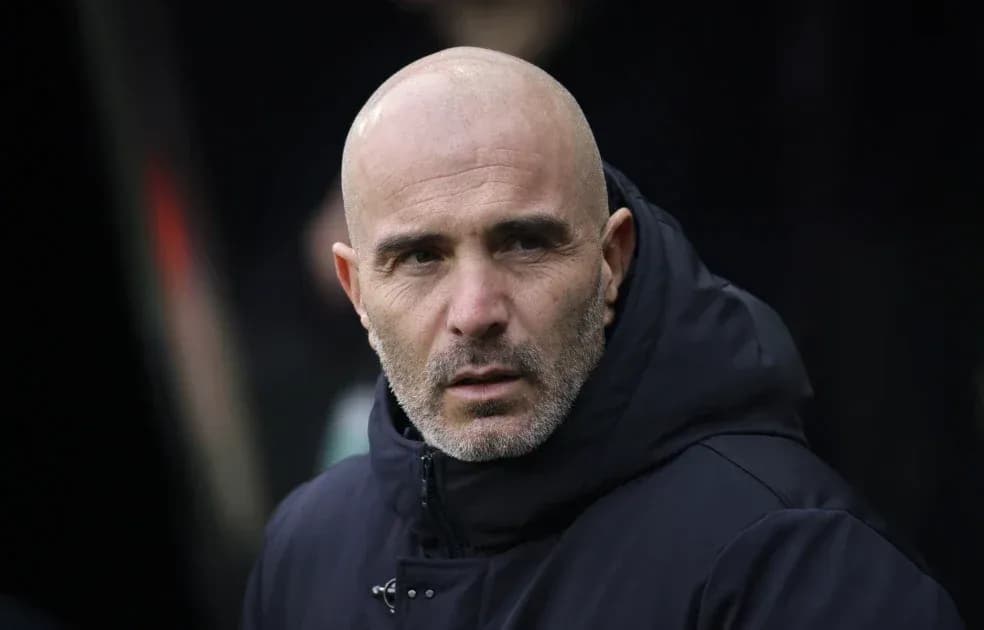 Entrenador observando desde el banquillo durante el partido Entrenador observando desde el banquillo durante el partido