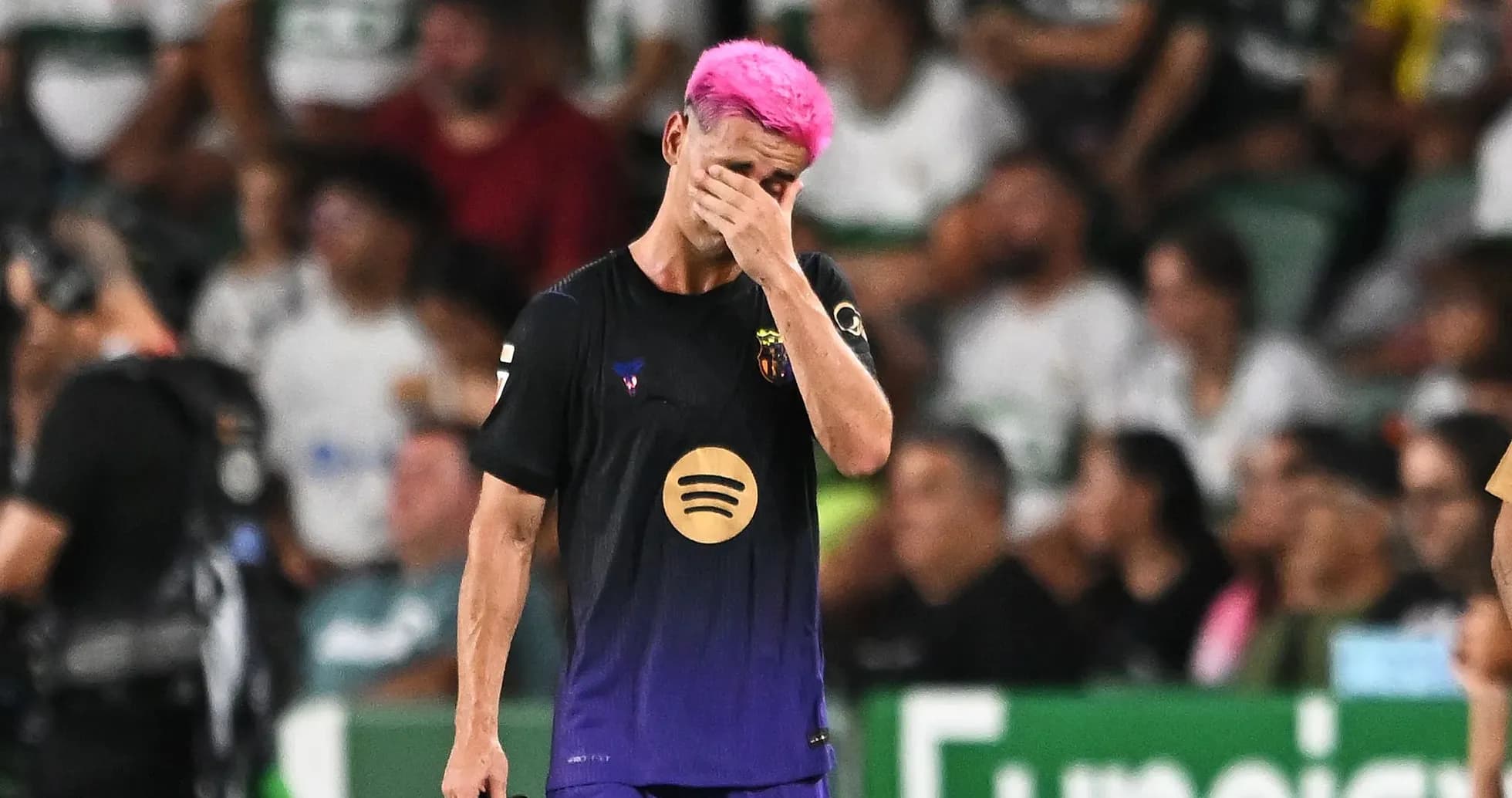 Jugador de fútbol con cabello rosa caminando cabizbajo Jugador de fútbol con cabello rosa caminando cabizbajo