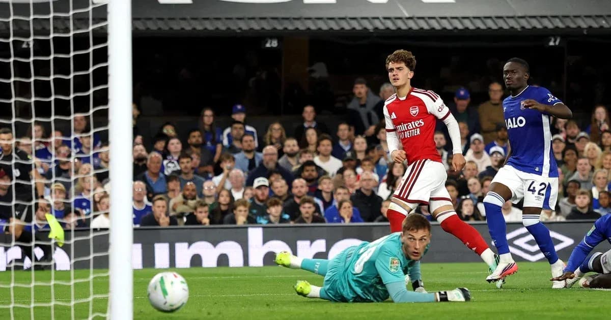 Jugador de Arsenal anotando gol ante el portero rival Jugador de Arsenal anotando gol ante el portero rival