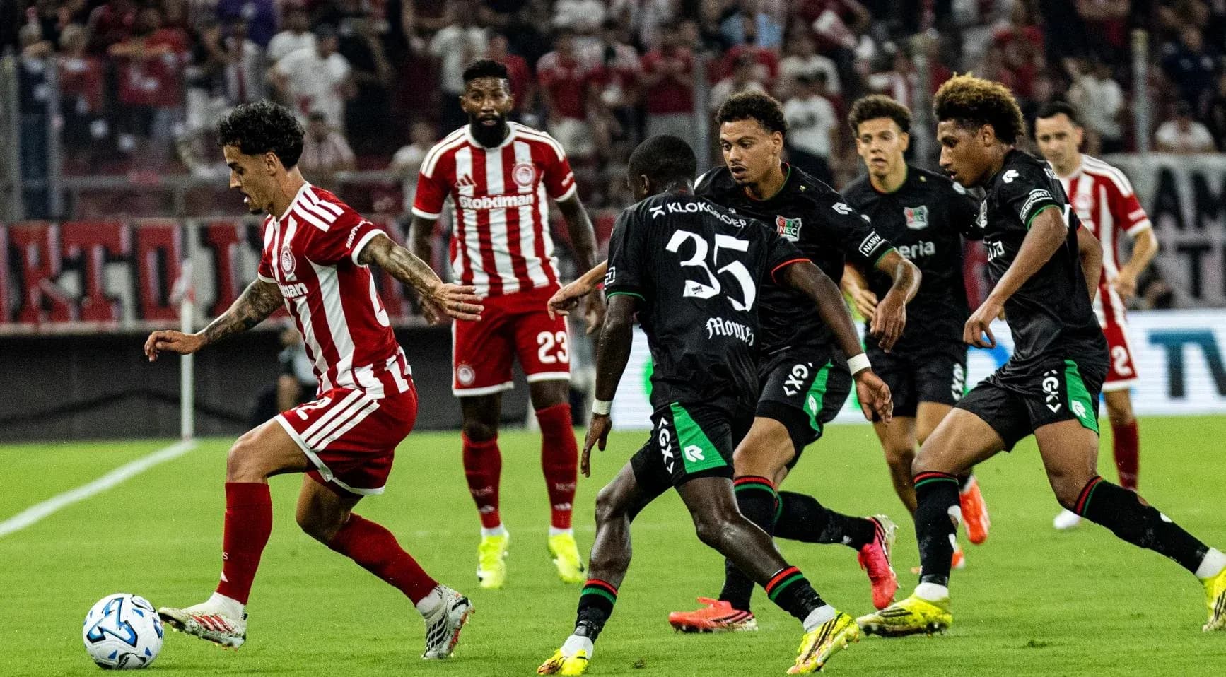 Jugador de Olympiakos driblando a defensores de NEC Jugador de Olympiakos driblando a defensores de NEC