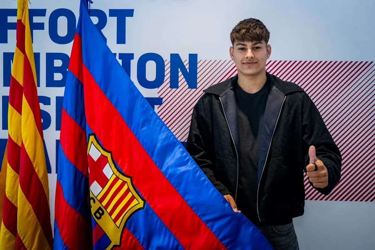 Jugador sosteniendo bandera del FC Barcelona en evento Jugador sosteniendo bandera del FC Barcelona en evento
