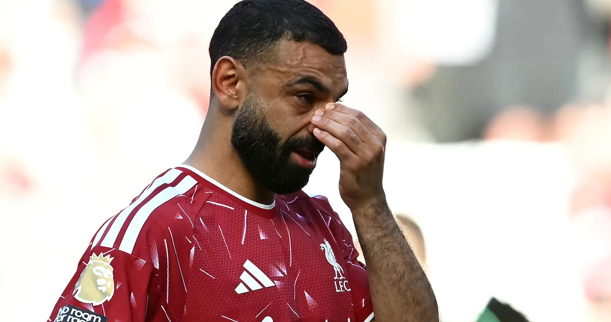 Jugador de Liverpool tocándose la cara en el campo Jugador de Liverpool tocándose la cara en el campo
