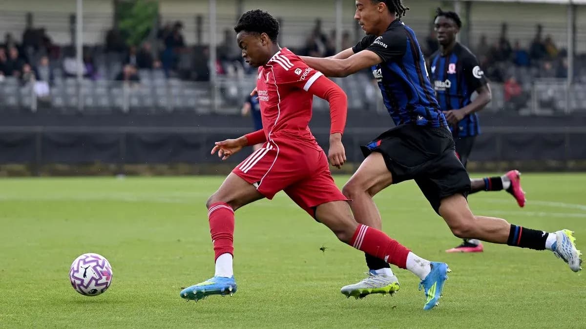Jugador del Liverpool corriendo mientras es perseguido Jugador del Liverpool corriendo mientras es perseguido
