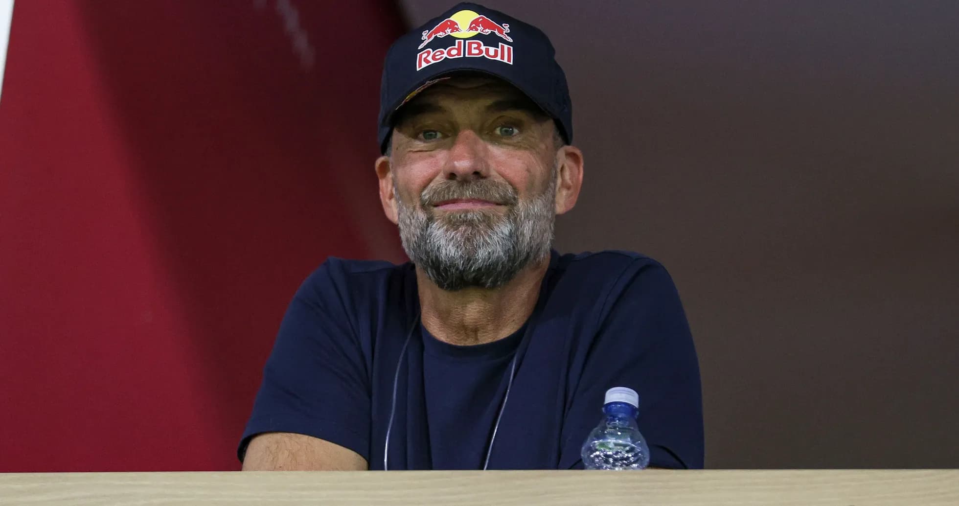 Hombre con gorra de Red Bull observando desde un palco Hombre con gorra de Red Bull observando desde un palco