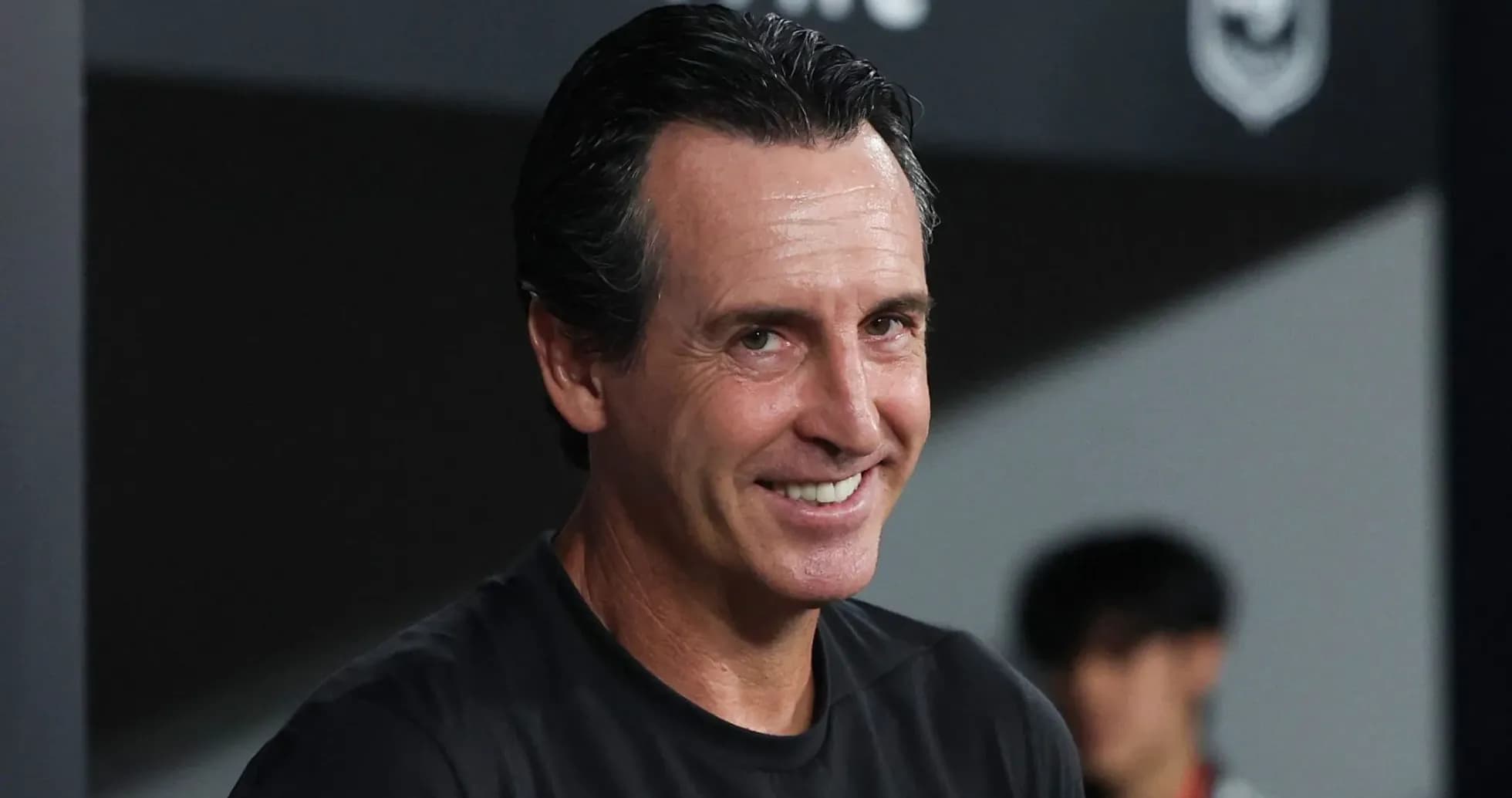 Entrenador sonriendo en el banquillo durante el partido Entrenador sonriendo en el banquillo durante el partido